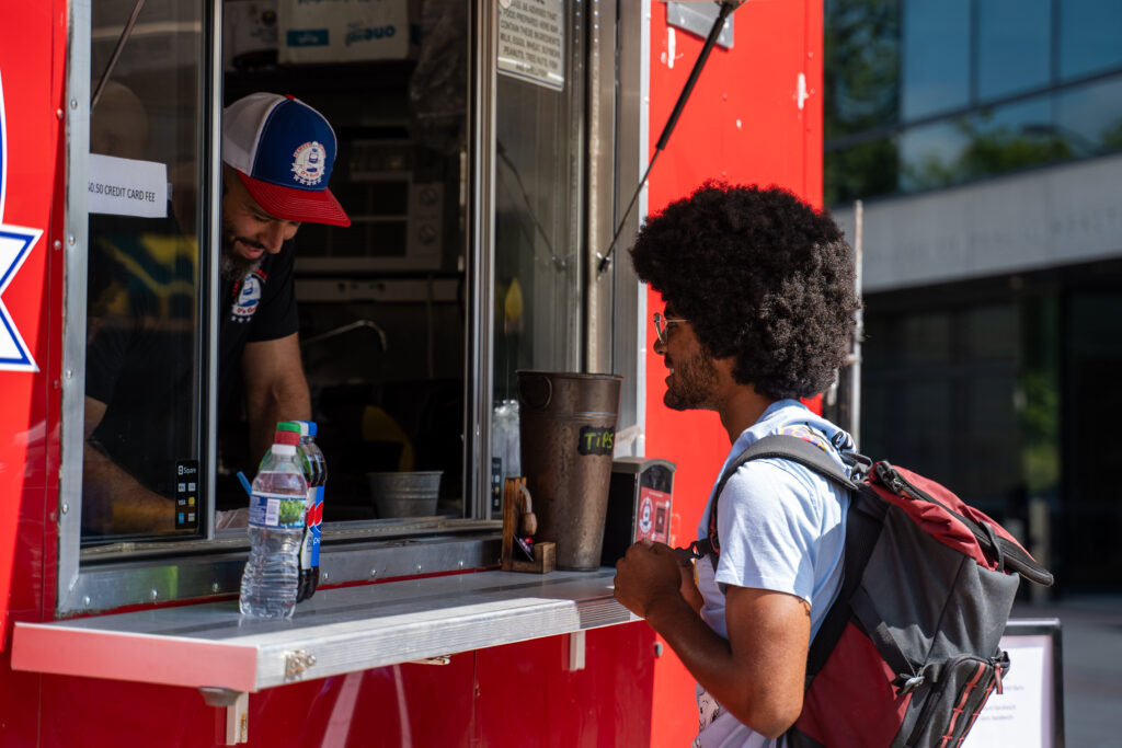 a student orders food at a food truck window